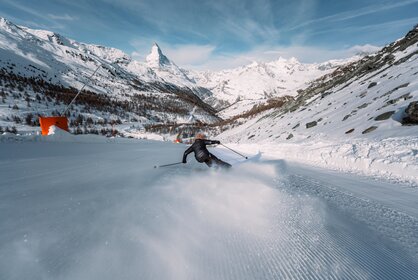Un skieur skie sur une piste fraîchement préparée. Au premier plan, on aperçoit les montagnes de Zermatt et le Cervin. | © Zermatt Bergbahnen