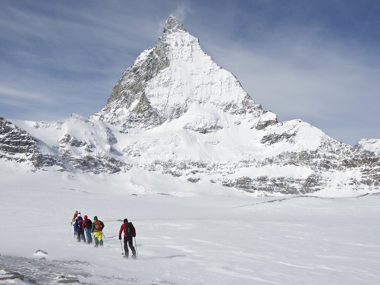 Eine Gruppe Schneeschuhläufer vor dem Matterhorn | © Michi_Portmann