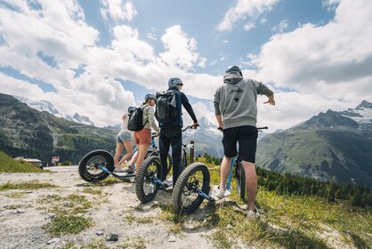 Un groupe profite de la vue sur Sunnegga avant de s'aventurer dans la descente en kickbike.  | © Gabriel Perren