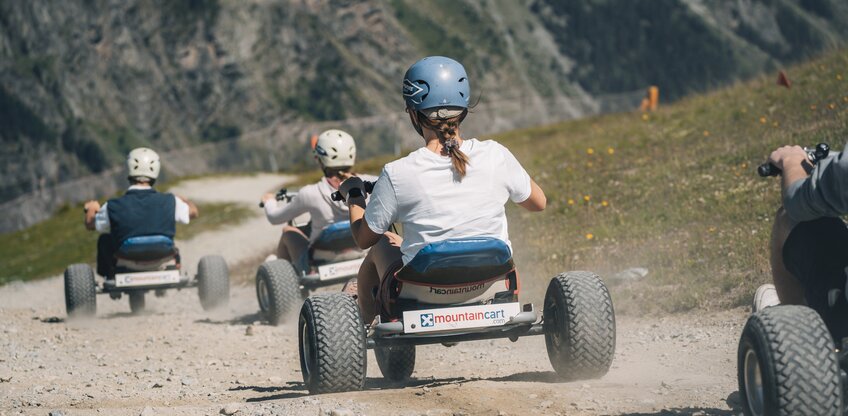 A group jets down the mountain on the mountain carts.  | © Gabriel Perren