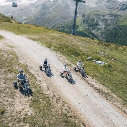 A group jets down the mountain on the mountain carts.  | © Gabriel Perren